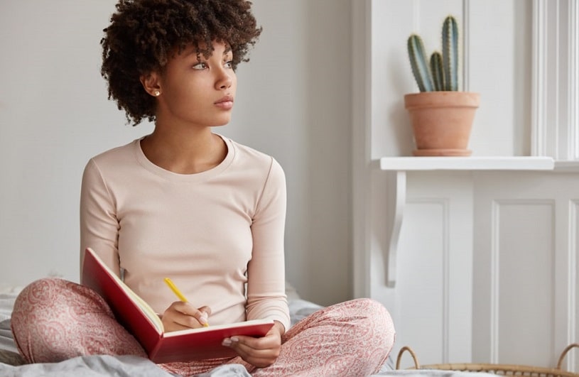 Woman taking notes and writing her recovery goals.