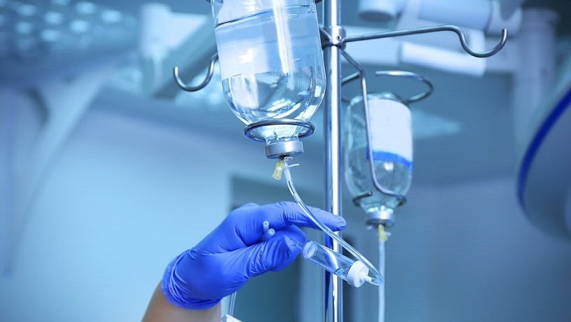 Doctor holding IV infusion drip in the hospital.