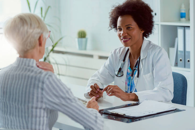 Private rehab specialist examining elderly female patient.