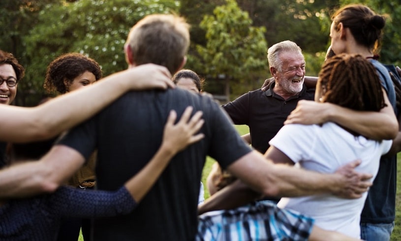 Group of people outdoors supporting each other.