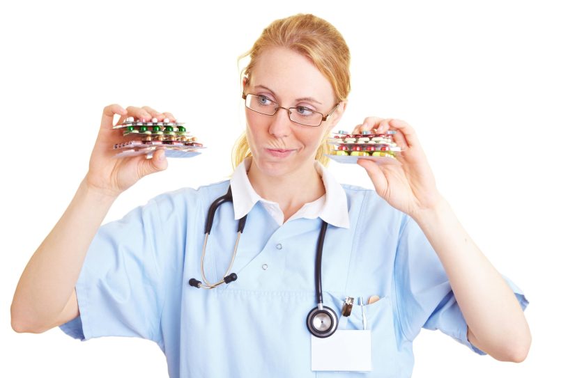 Nurse is holding many colorful pills