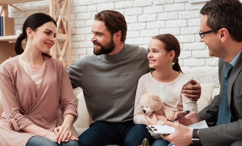 Happy family and a psychologist talking.