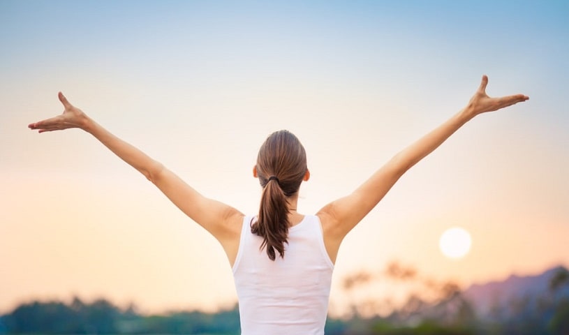 Happy confident woman raising her arms.