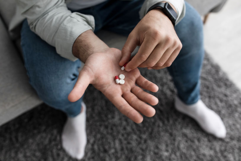 Trazodone pills in the hand of a man.