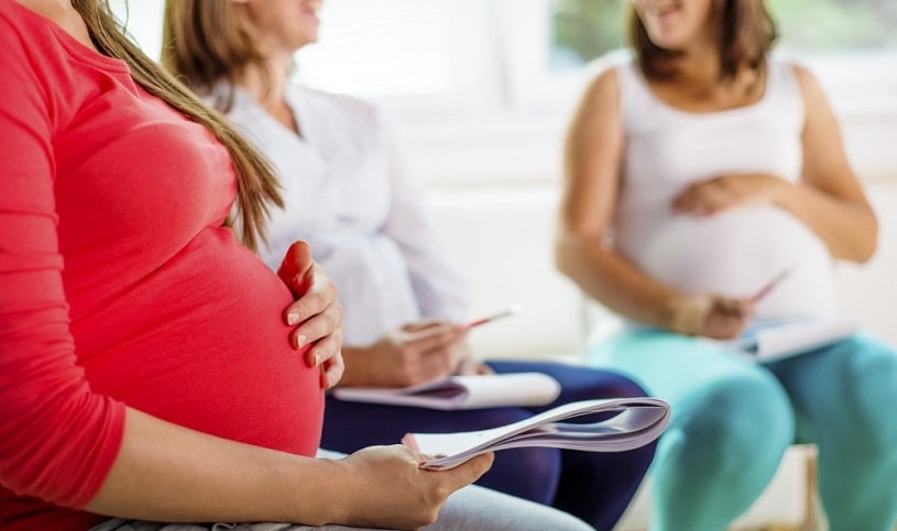 A group of pregnant women supporting each other at a meeting.