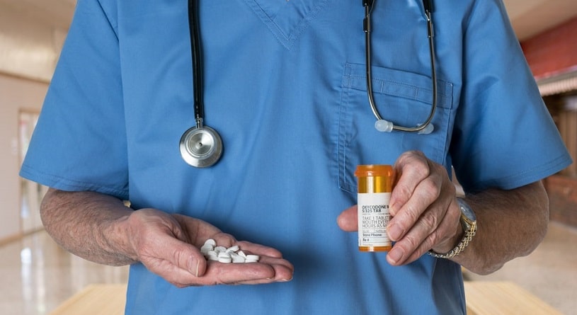 Doctor holding a bottle of prescription pills.