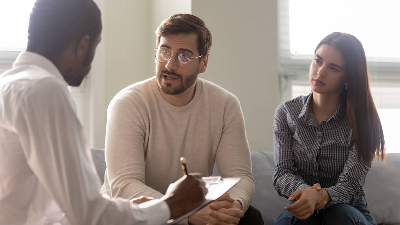 Disappointed couple talking with rehab therapist.