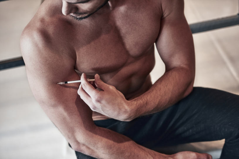 A man makes an injection of anabolic steroids in his hand.