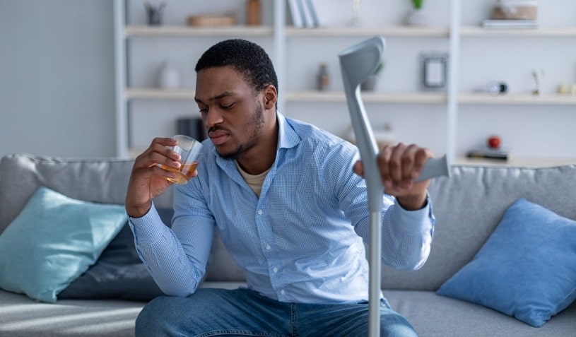A man with PTSD drinks alcohol at home.
