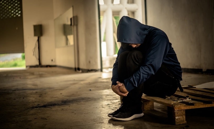 Depressed drug addict sitting alone.