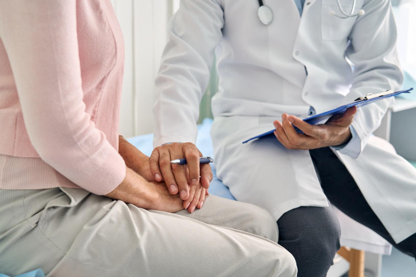 A doctor puts his hand over the patient's hands.
