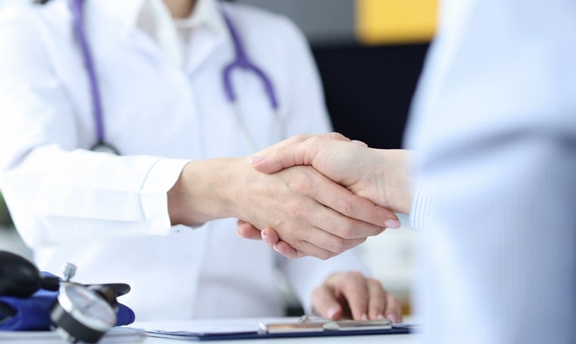 Doctor and patient shake hands.