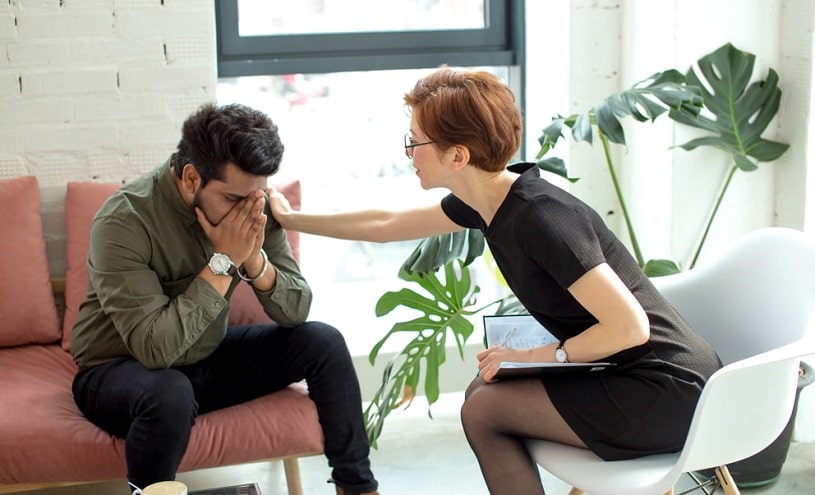 Female psychiatrist cheering up a young man.