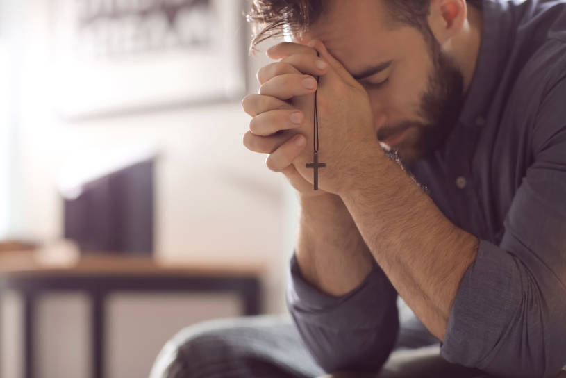 Religious young man praying.