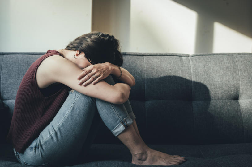 An anxious woman covers her face with hands.