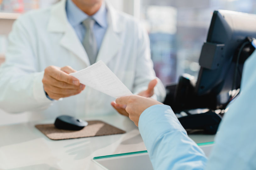 A doctor gives a prescription to a patient.